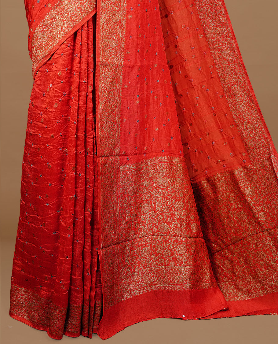 Red colour Banarasi Bandhani silk saree featuring intricate antique zari circle Buttas across the body, complemented by an elegant antique zari border. Comes paired with a matching blouse piece