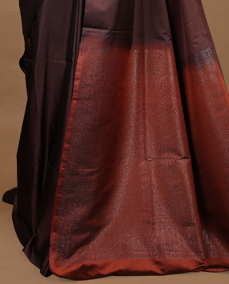 Chocolate colour soft silk saree features a sleek borderless design with intricate antique zari motifs, flowing into a striking contrast burnt orange and a matching blouse piece.