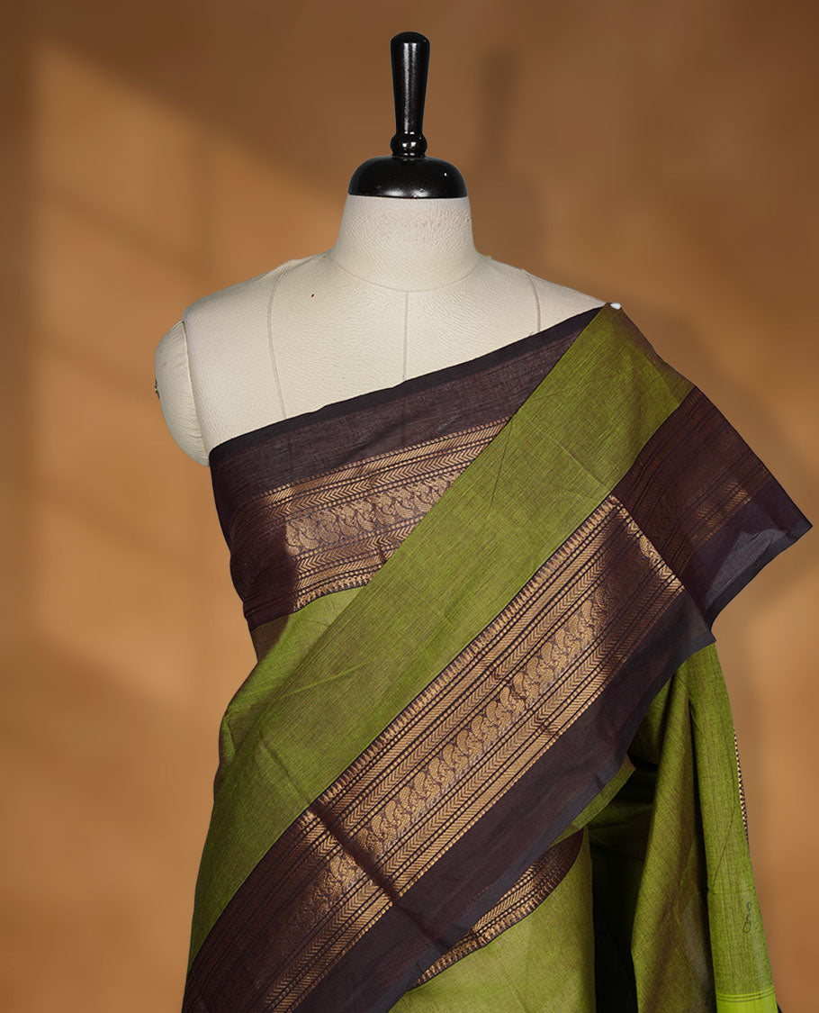 Olive green colour chettinad cotton saree featuring plain body, contrast Dark Brown colour with traditional gold zari border without blouse.