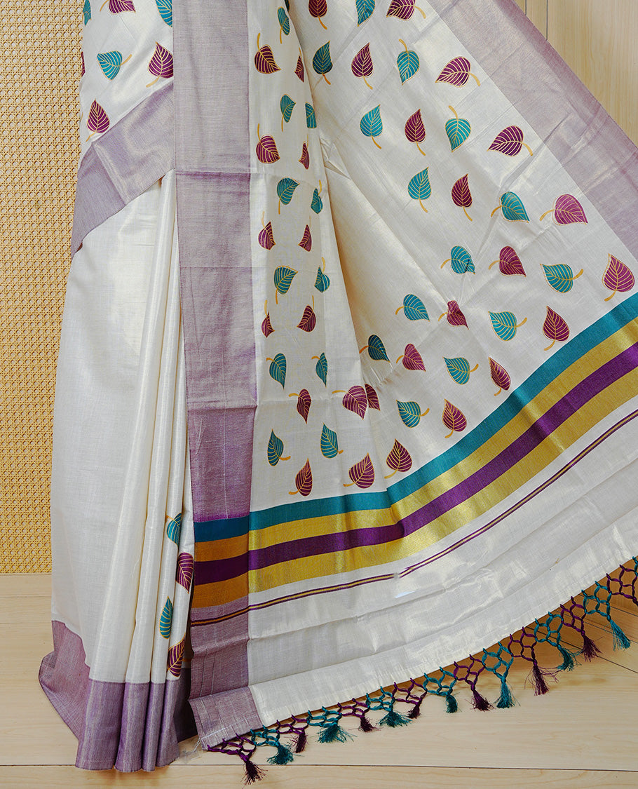 Cream Colour Tissue Kerala Saree Featuring Green and Brown Leaf Prints Across the Body, Enhanced with a Gold Zari, Purple and Green Border & Pallu, Green  and Purple  Tassels, and a Matching Blouse Piece.
