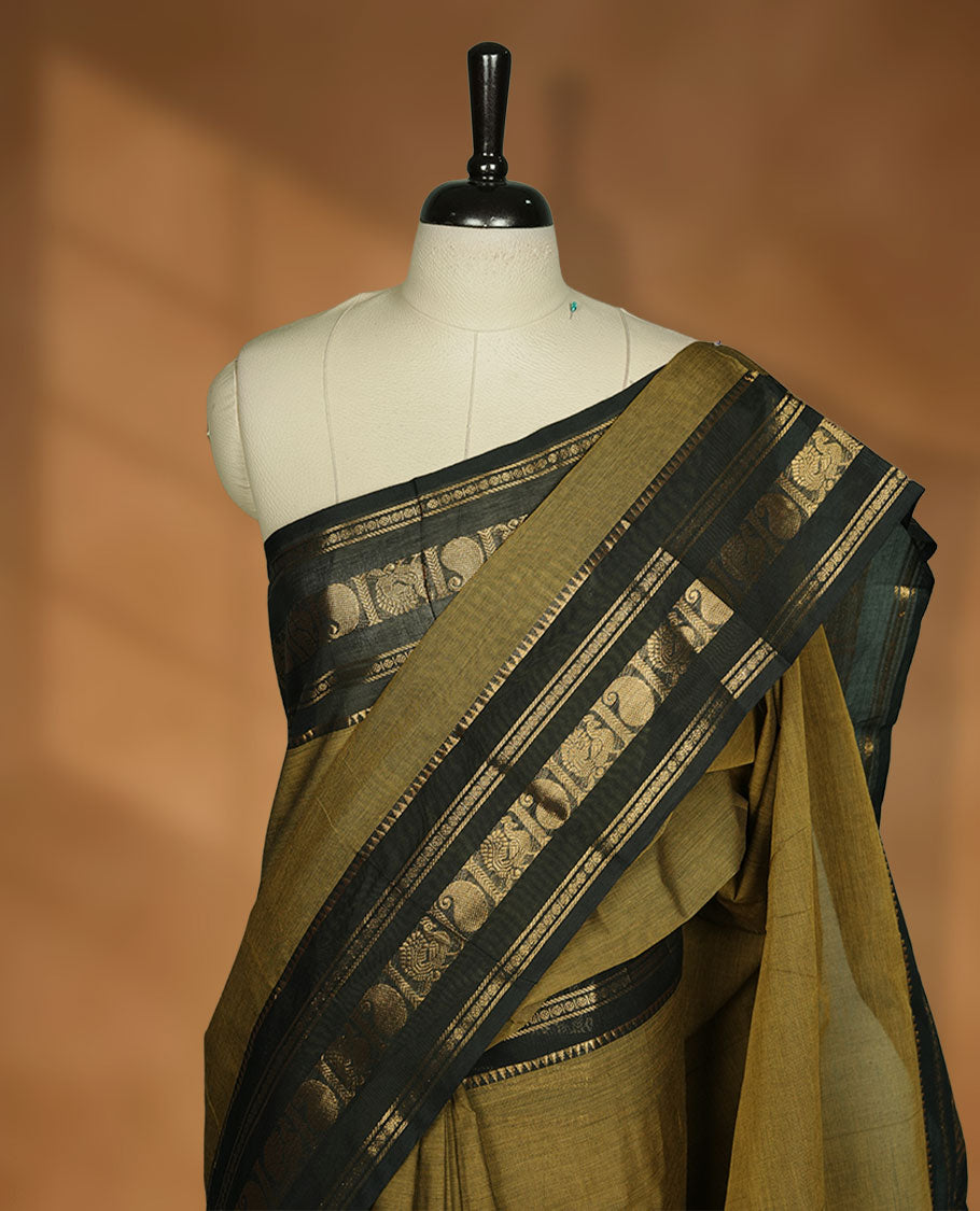 Mehandi colour chettinad cotton saree featuring plain body, contrast black colour with traditional gold zari border paired with matching blouse.