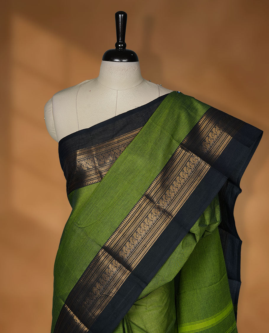 Green colour chettinad cotton saree featuring plain body, paired with a charcoal black colour traditional gold zari border without blouse.