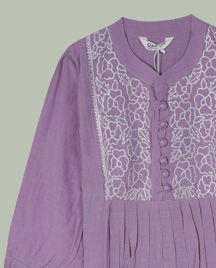 Lilac three-quarter sleeve tunic top with rounded band neckline, white floral embroidered yoke, fabric-covered button placket, and soft pleating below the yoke.