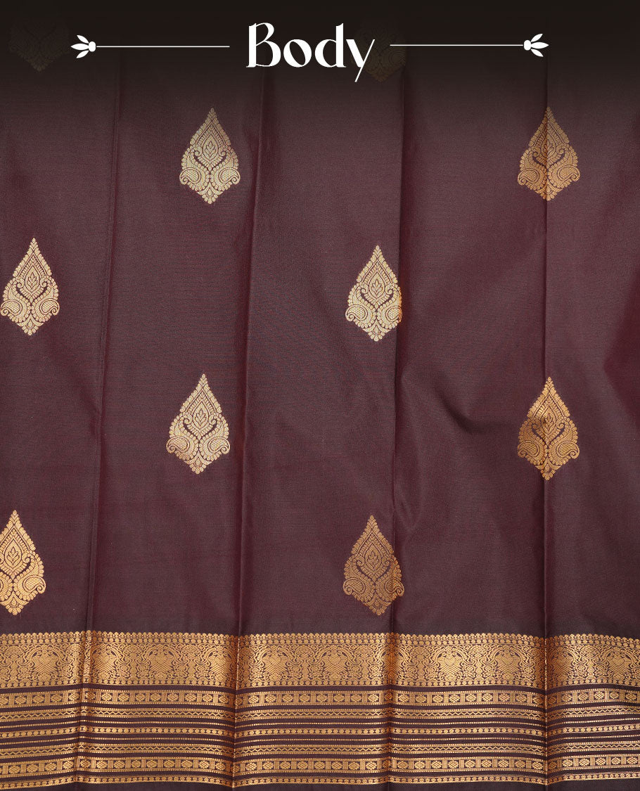 Chocolate colour soft silk saree featuring Gold zari motifs on body, complemented by self colour with traditional border, paired with matching blouse piece.