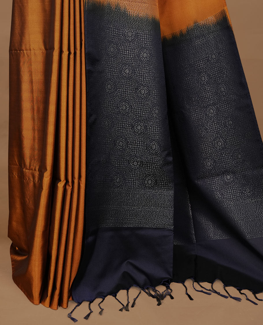 Mustard colour soft silk saree features a sleek borderless design with intricate antique zari motifs, flowing into a striking contrast blue pallu and a matching blouse piece.