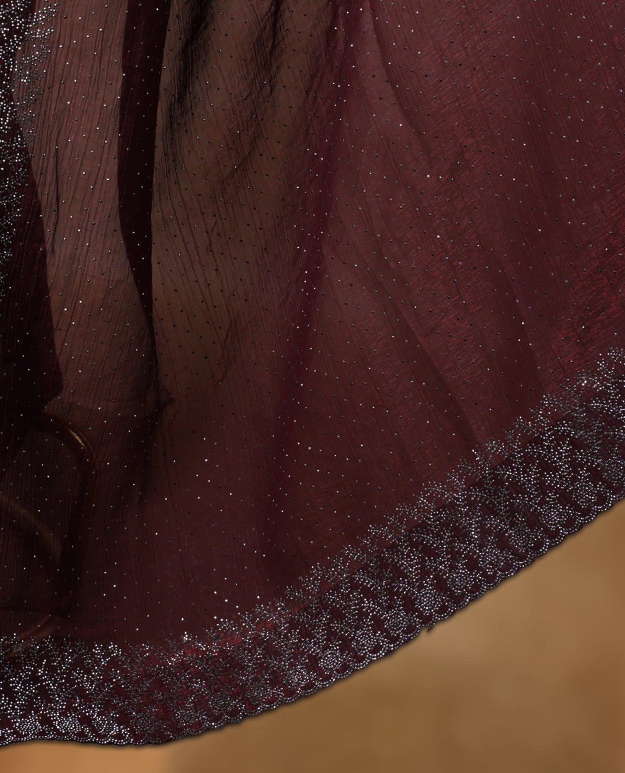 Chocolate brown colour chiffon designer saree, featuring white stone all over on body, heavy stone patttern on border and  pallu, Paired with matching blouse.