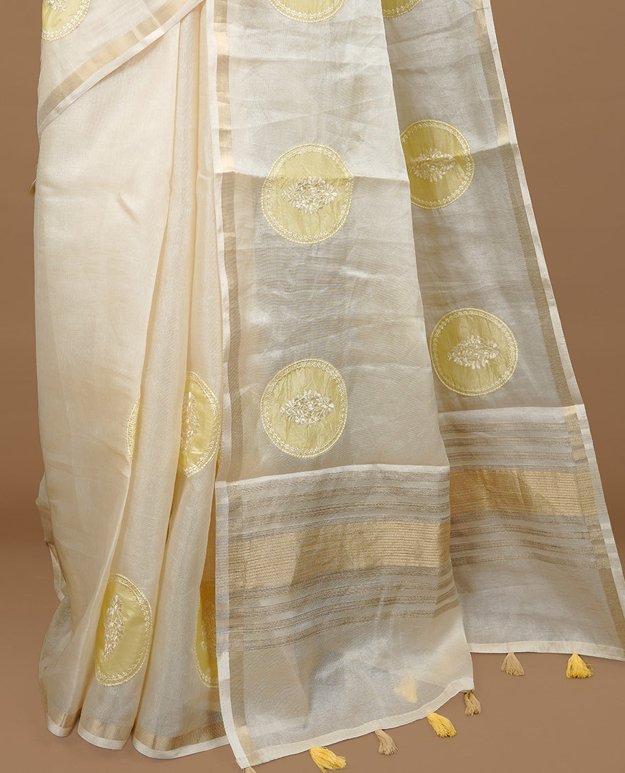 Cream colour Tussar saree featuring yellow colour circle pattern with chikankari embroidery work, highlighting gold zari simple border, paired with matching unstitched blouse.