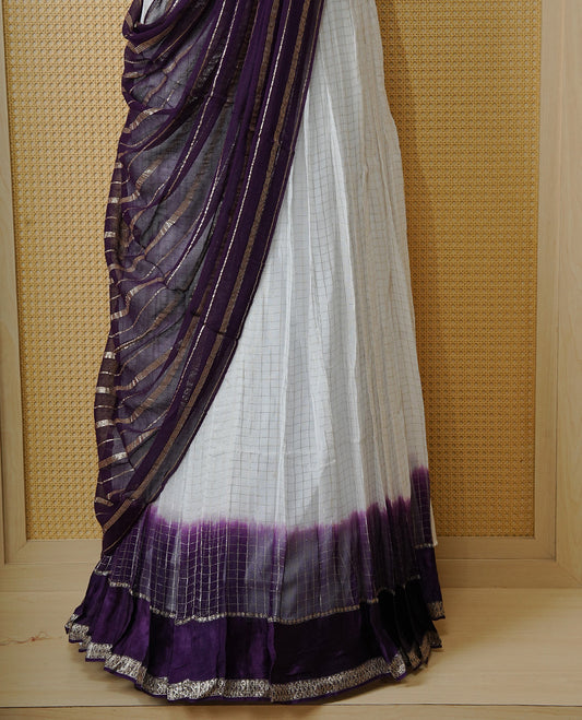 Off white colour Semi stitched dhavani set featuring Gold zari check pattern with contrast Violet border skirt, paired with matching blouse & dupatta.