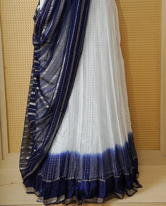 Off white colour Semi stitched dhavani set featuring Gold zari check pattern with contrast Navy blue border skirt, paired with matching blouse & dupatta.