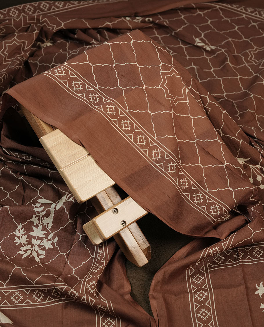 Chocolate brown colour churidar material featuring delicate thread embroidery with subtle mirror accents on the front panel, paired with a printed dupatta and matching bottom.