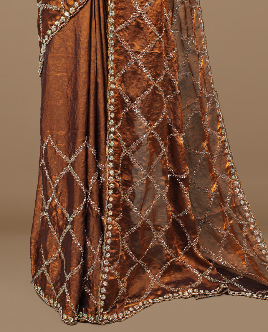 Golden Brown colour designer saree featuring Sequins & cut beats worked body, cut beat worked border, paired with matching unstitched blouse.