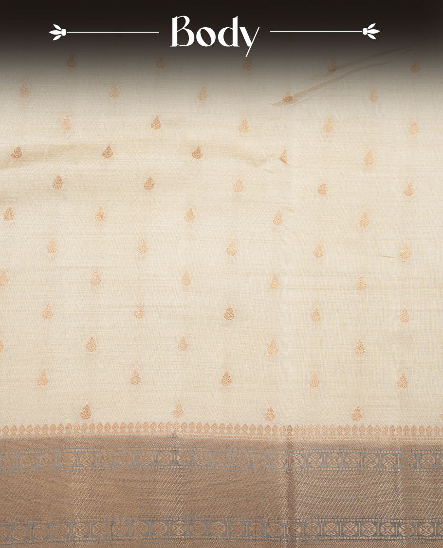 Cream colour tussar saree featuring litte gold zari motifs on body, contrast grey colour border and pallu with zari woven design, comes with matching blouse piece.
