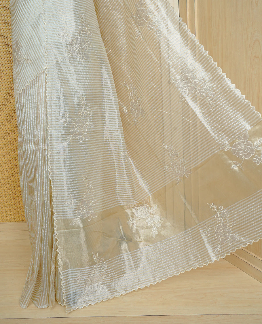 Cream colour Organza Saree featuring floral thread Work & Gold zari strip Design on body, Scallop border, comes with matching blouse piece.