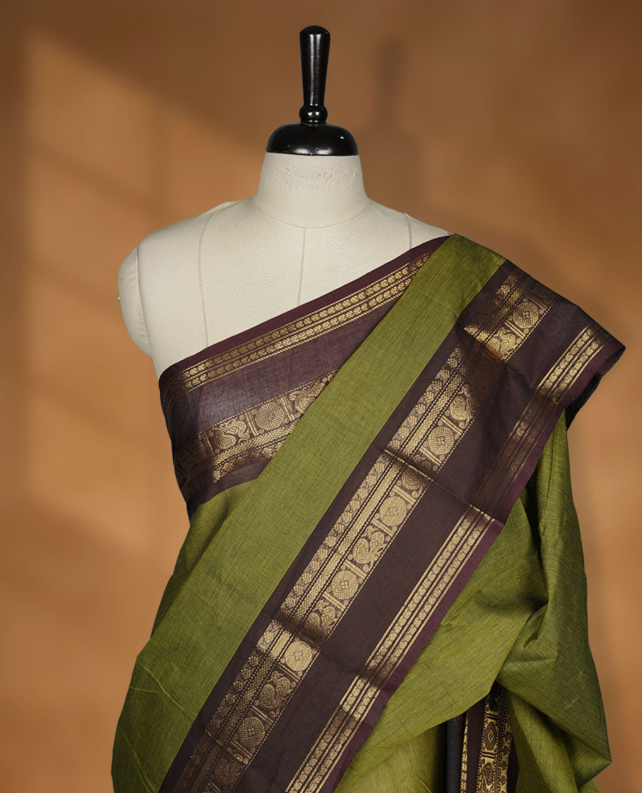 Olive colour chettinad cotton saree featuring plain body, contrast chocolate brown colour with traditional gold zari border paired with matching blouse.