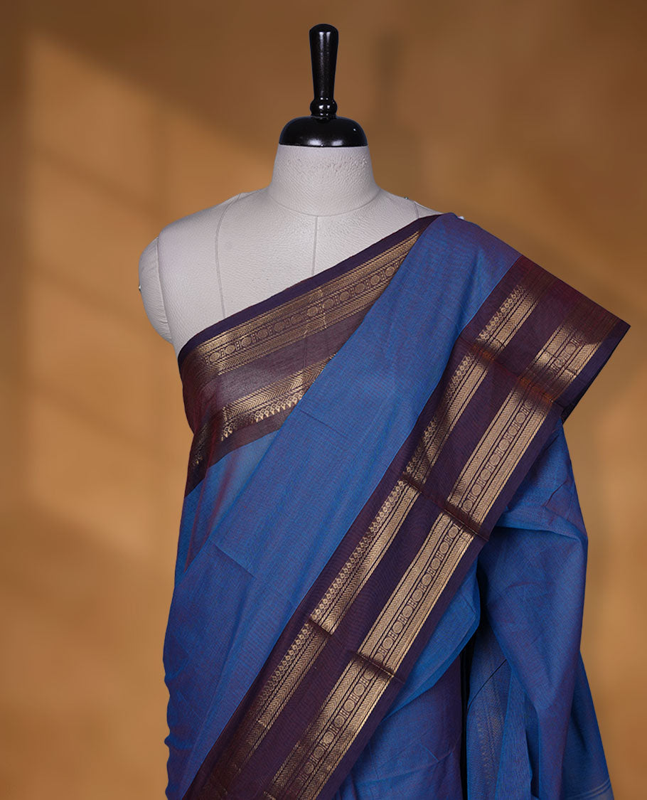 Blue colour chettinad cotton saree featuring Elegant body, contrast purple colour border with gold zari border, pallu and paired with matching blouse.