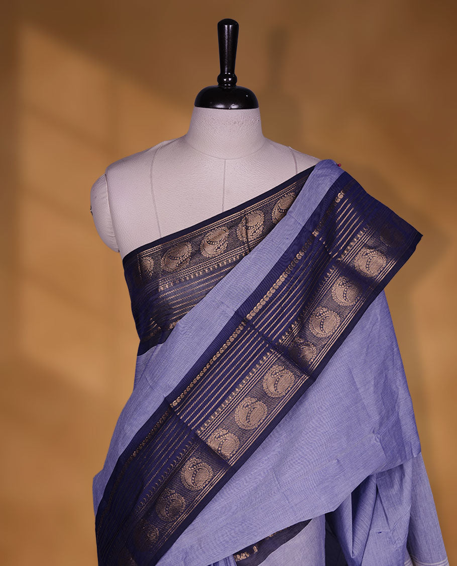 Lavender colour chettinad cotton saree featuring plain body, contrast Dark blue colour with traditional gold zari border paired with matching blouse.