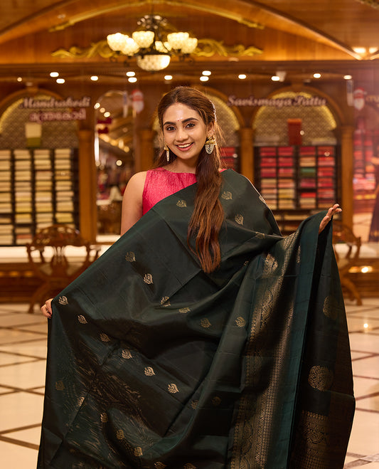 Bottle green pure Mayuri Soft silk saree adorned with elegant antique zari motifs across the body, featuring a traditional antique zari pallu and a refined one side border, gracefully paired with a matching blouse