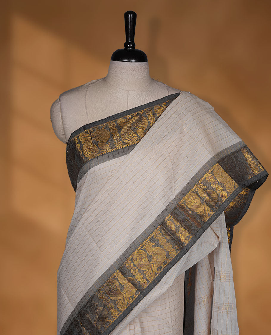 Beige colour chettinad cotton saree featuring gold zari check patterned body, paired with a grey colour traditional gold zari border without blouse.