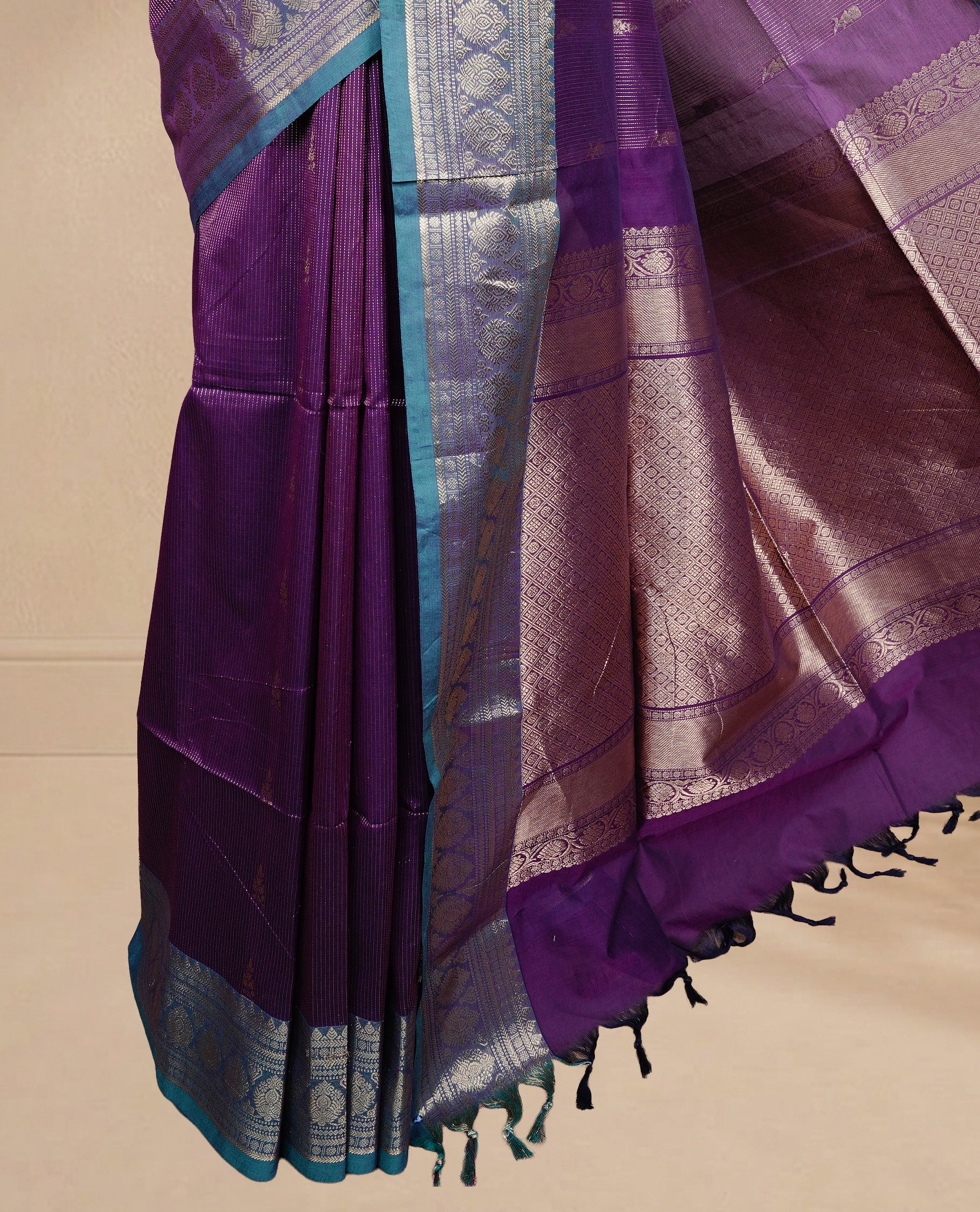 Purple colour chettinad cotton saree featuring gold zari stripes & motifs on body, complemented by Contrast Green colour with zari border, paired with matching blouse piece.