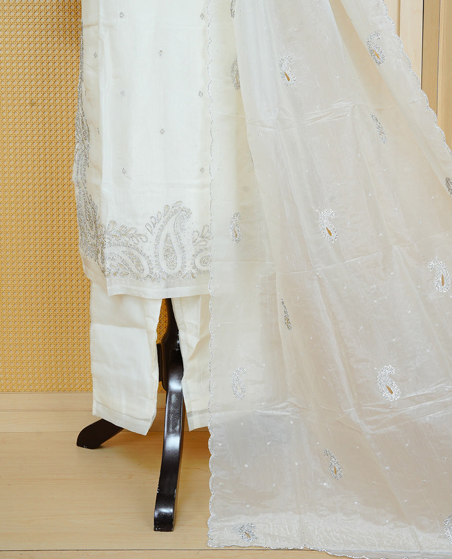 Off White colour churidar set featuring delicate Stone Work on the V-neckline, sleeves and hem, paired with matching solid pants and an embellished sheer dupatta.