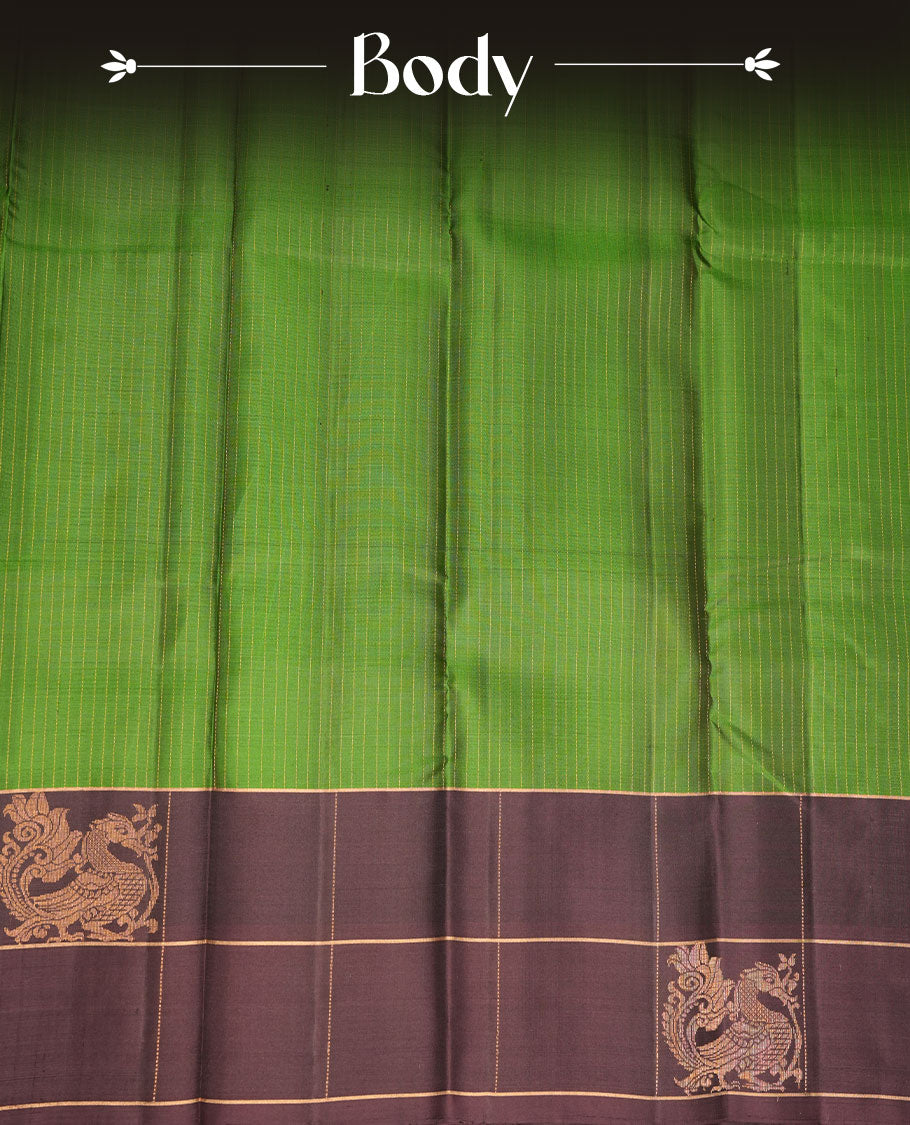 Green colour soft silk saree featuring elegant gold zari stripes across the body, complemented by a contrast burgundy with peacock buttas on border, and paired with a matching blouse piece.