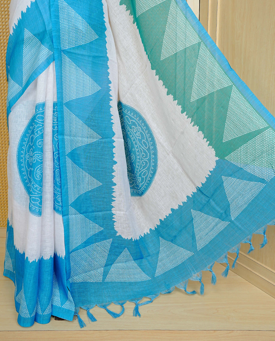 Cream colour semi linen saree featuring Blue Ajrakh pattern print on body, complemented by contrast Green colour with same pattern print Blue border, comes with matching blouse piece.