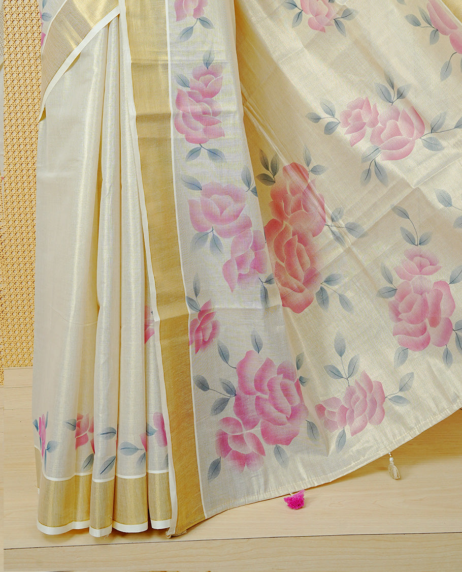 Cream Colour Tissue Kerala Saree Featuring Digital  Pink Rose Prints Across The Body, Enhanced With A Gold Zari Border , Finished With Pink & Cream Tassels And A Matching Blouse Piece