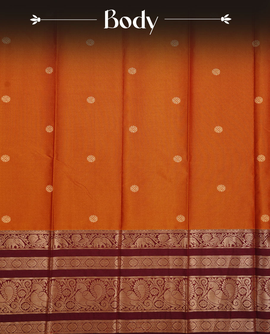 Burnt mustard colour soft silk sareee featuring gold zari Motifs on body, complemented by contrast Maroon colour with zari border, paired with matching blouse piece.