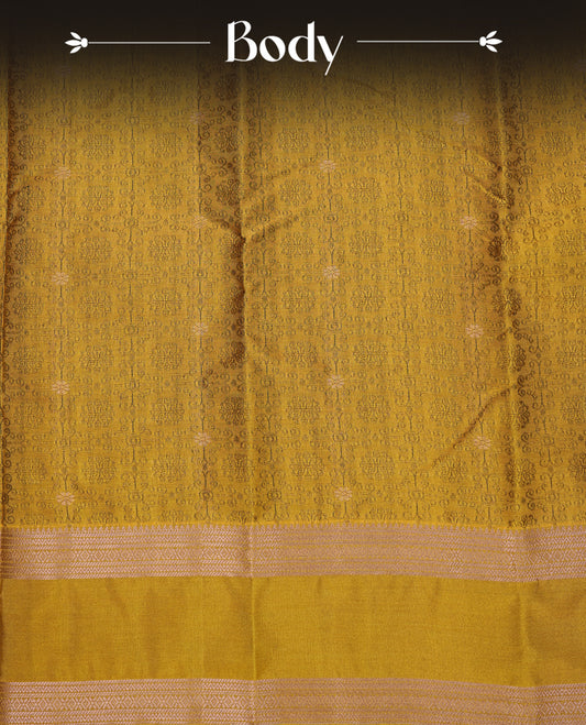 Mustard Yellow Colour  Semi Soft Slik  Saree Featuring An Elegant Self Floral Woven Body, Enhanced By A Traditional Rose Gold Zari Border And Rich Pallu, Paired With A Matching Blouse Piece.