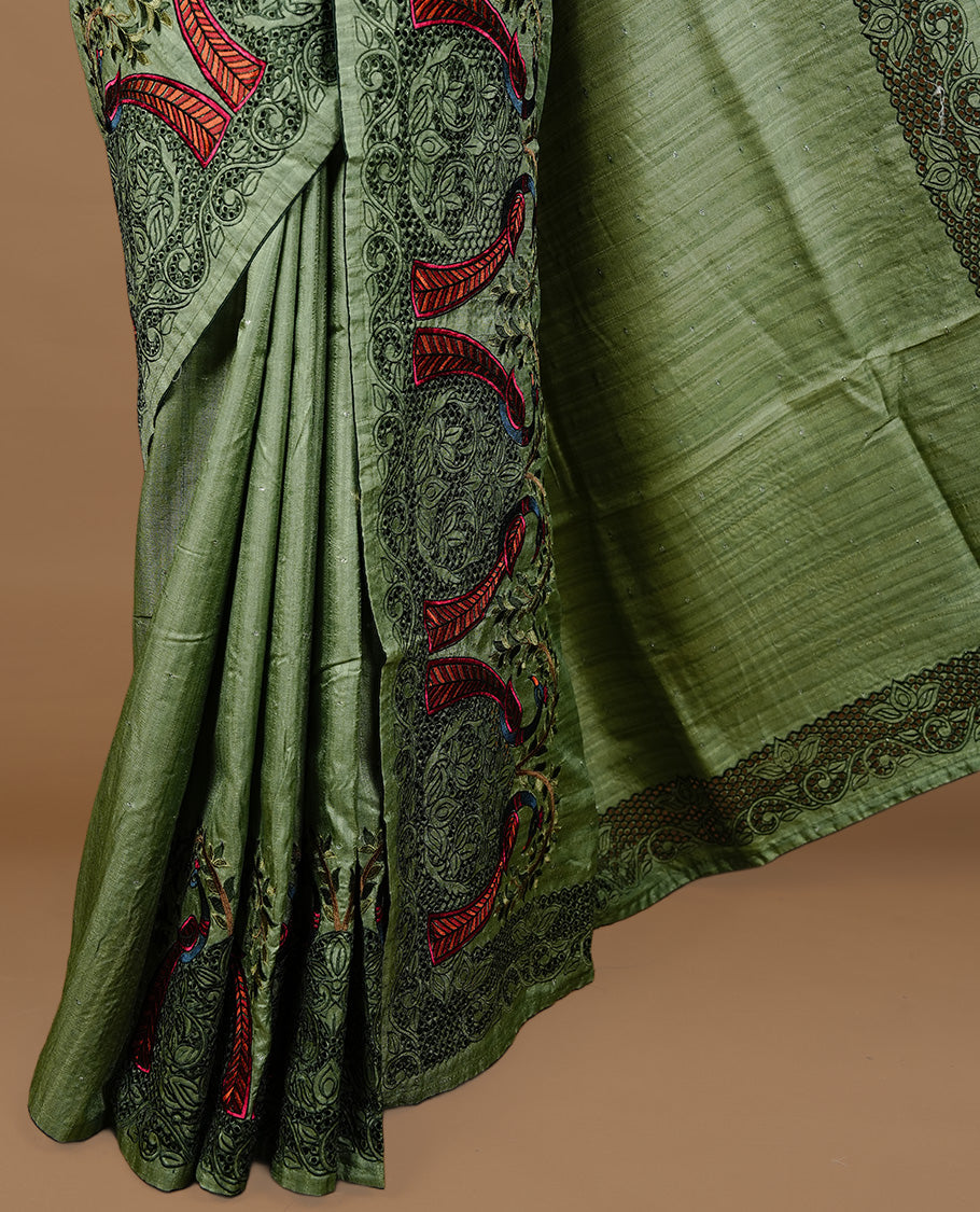 Green colour Semi Tussar silk saree features an intricate cutwork embroidered peacock motifs on border, paired with a matching unstitched blouse piece.