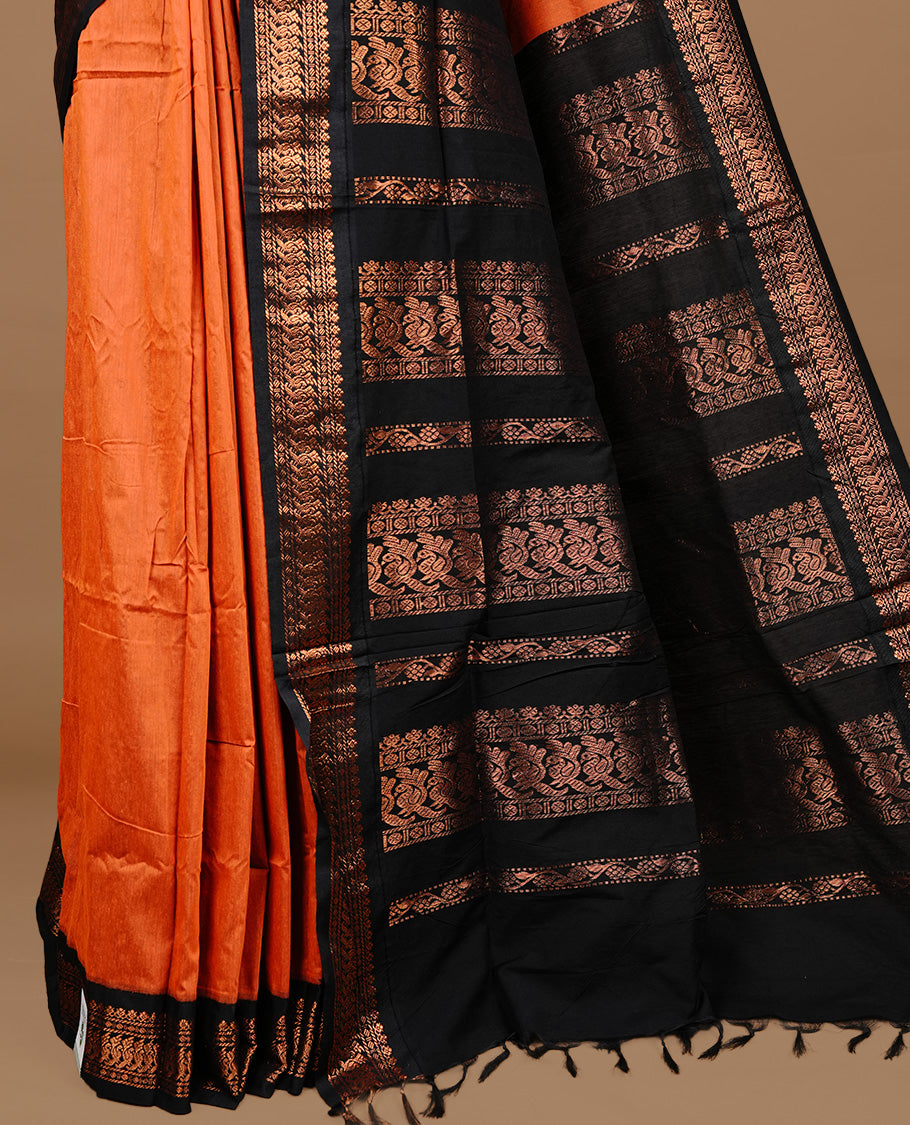 Orange colour kalyani cotton saree featuring gold zari motifs on body, highlighting contrast Black colour with Antique gold zari border, paired with matching blouse piece.
