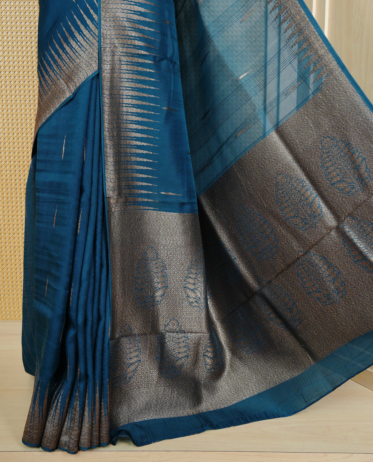 Teal colour semi banaras tussar georgette saree featuring gold zari pattern on body, finished with gold zari temple border and paired with matching blouse piece.
