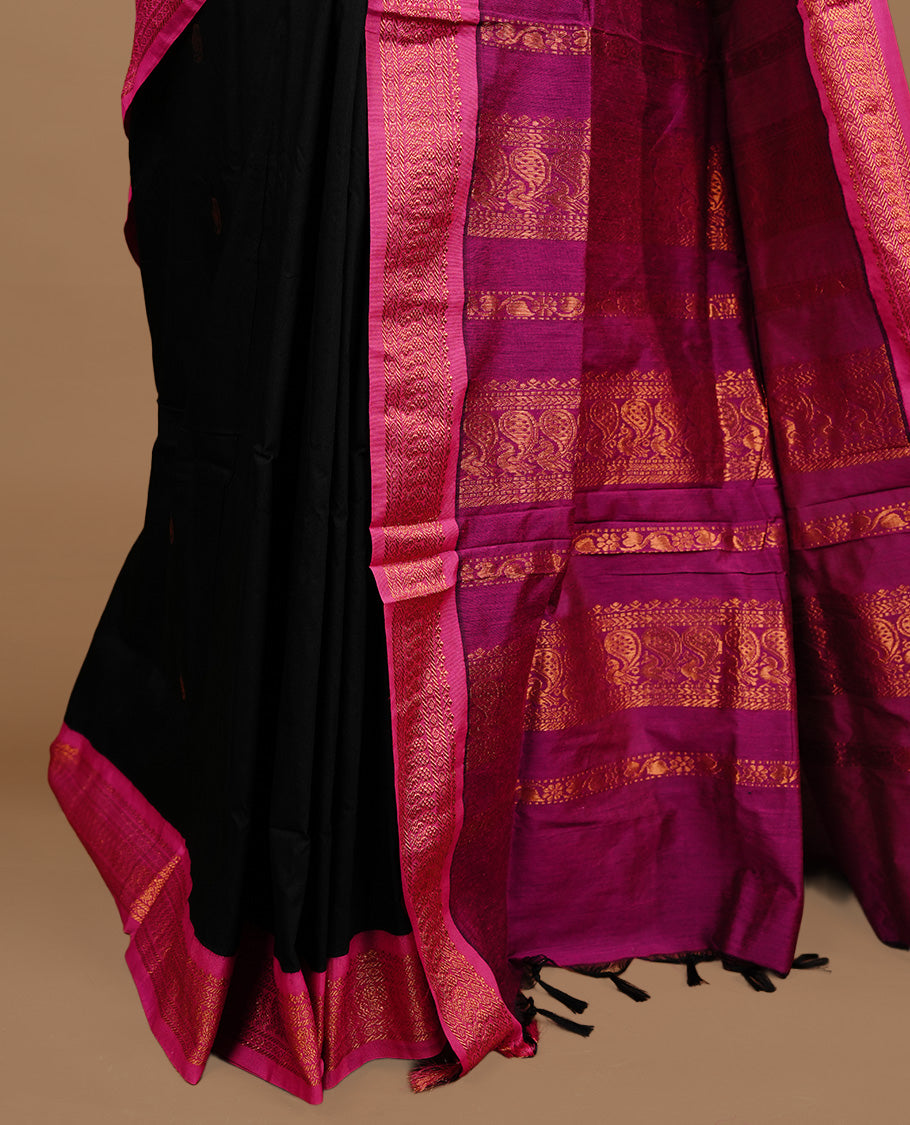 Black colour kalyani cotton saree featuring gold zari motifs on body, highlighting contrast Magenta colour with Antique gold zari border, paired with matching blouse piece.