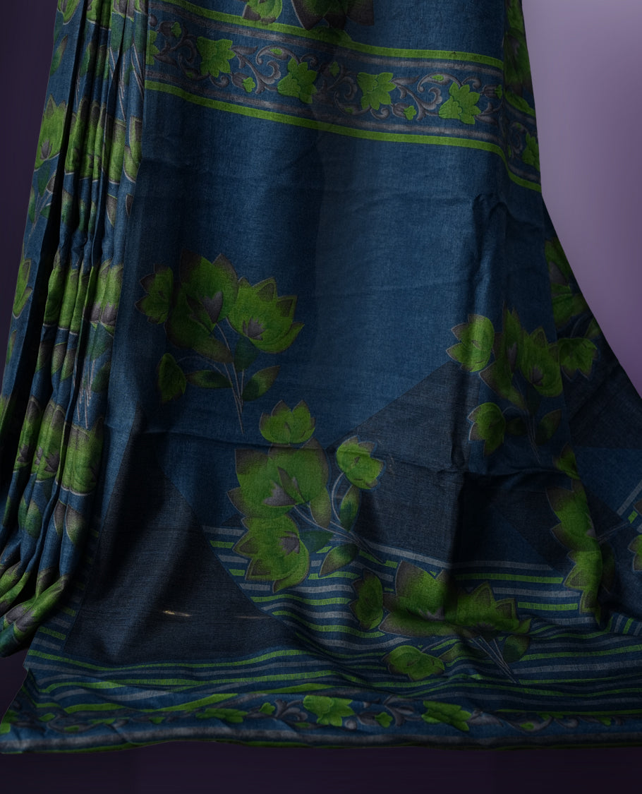 Deep Blue colour saree enhanced with a vibrant green colour floral prints on body & pallu, and  comes with a matching blouse.