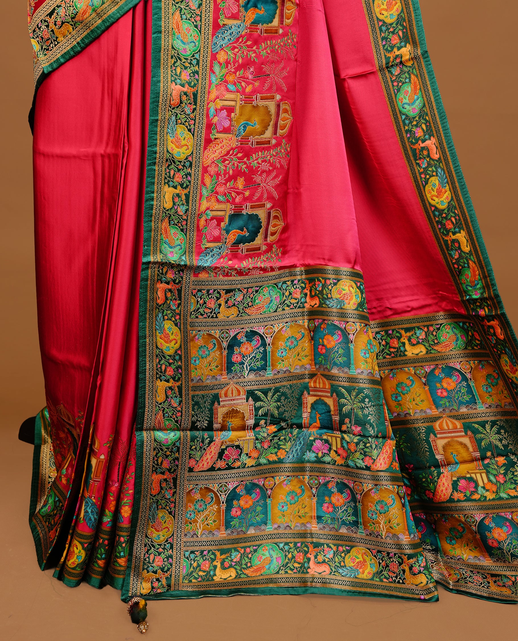 Pink colour Pashmina Saree featuring a plain lustrous body, a multicolour traditional woven border, a rich traditional woven pallu with architectural and floral motifs, paired with a matching pink blouse.