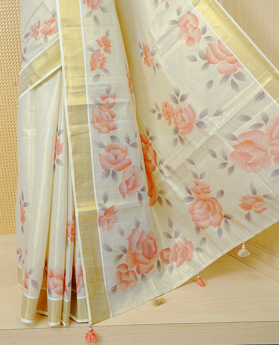 Cream Colour Tissue Kerala Saree Featuring Digital Peach Rose Prints Across The Body, Enhanced With A Gold Zari Border , Finished With Peach & White Tassels And A Matching Blouse Piece