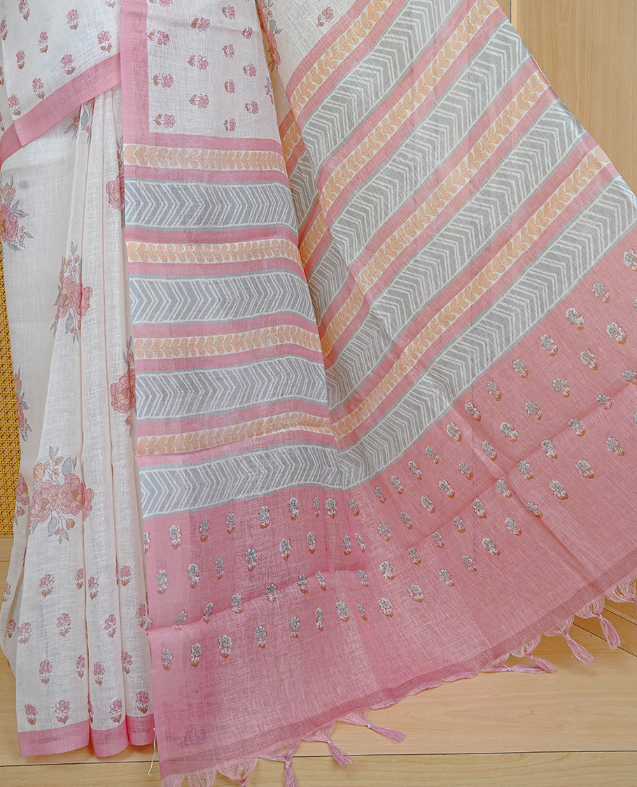 Cream colour semi linen saree featuring Floral printed buttas on body, complemented by contrast Peach colour border, comes with matching blouse piece.