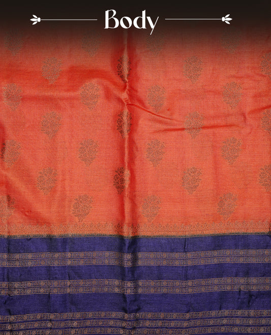 Rust orange colour pure tussar Banaras silk saree featuring elegant gold zari motifs across the body, complemented by a contrast Navy blue border with rich zari detailing. Comes with a matching blouse piece
