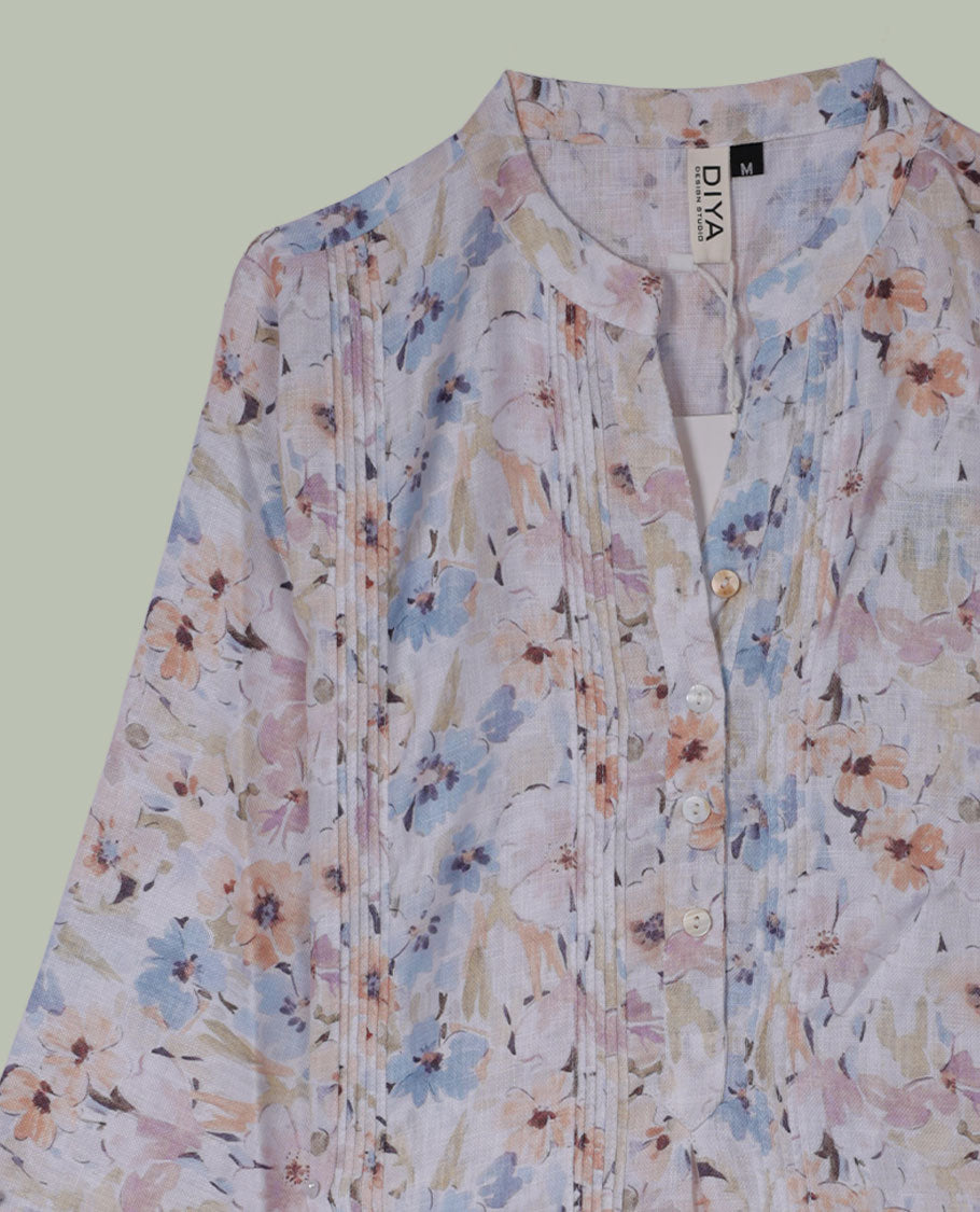 Pastel floral printed tunic top with band collar, pintuck-detailed front, half button placket, and three-quarter sleeves.