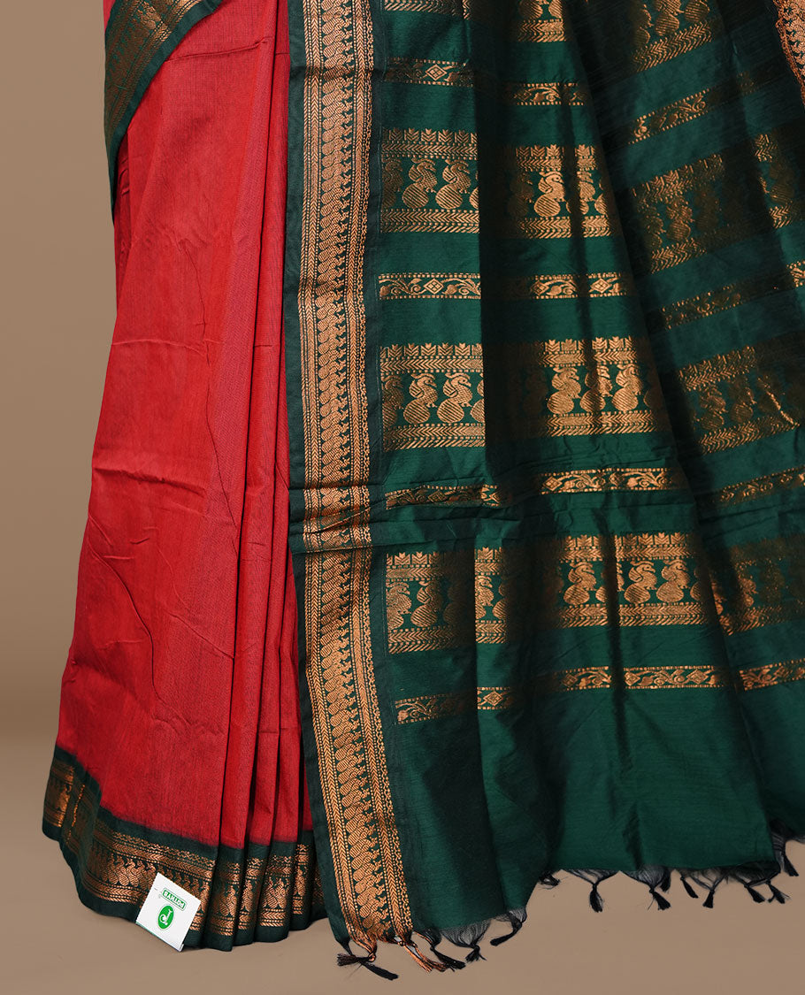 Red colour kalyani cotton saree featuring antique zari motifs on body, complemented by green colour with Antique zari border, paired with matching blouse piece.