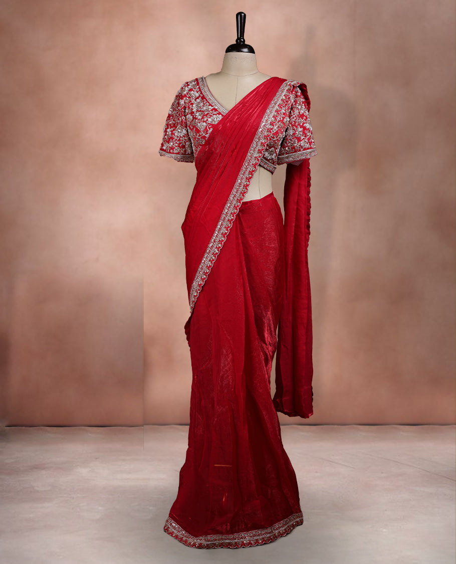 Elegant Bright Red Colour ready to wear saree adorned with rich silver zari and bead embroidery along the border and pallu, paired with a heavily embellished matching blouse for a grand festive look.