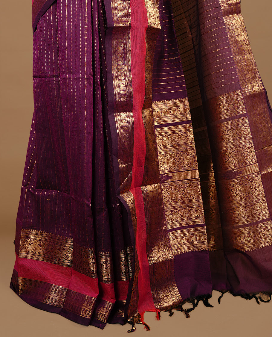Purple colour chettinad cotton saree featuring gold zari motifs on body, complemented by magenta colour with zari border, paired with matching blouse piece.