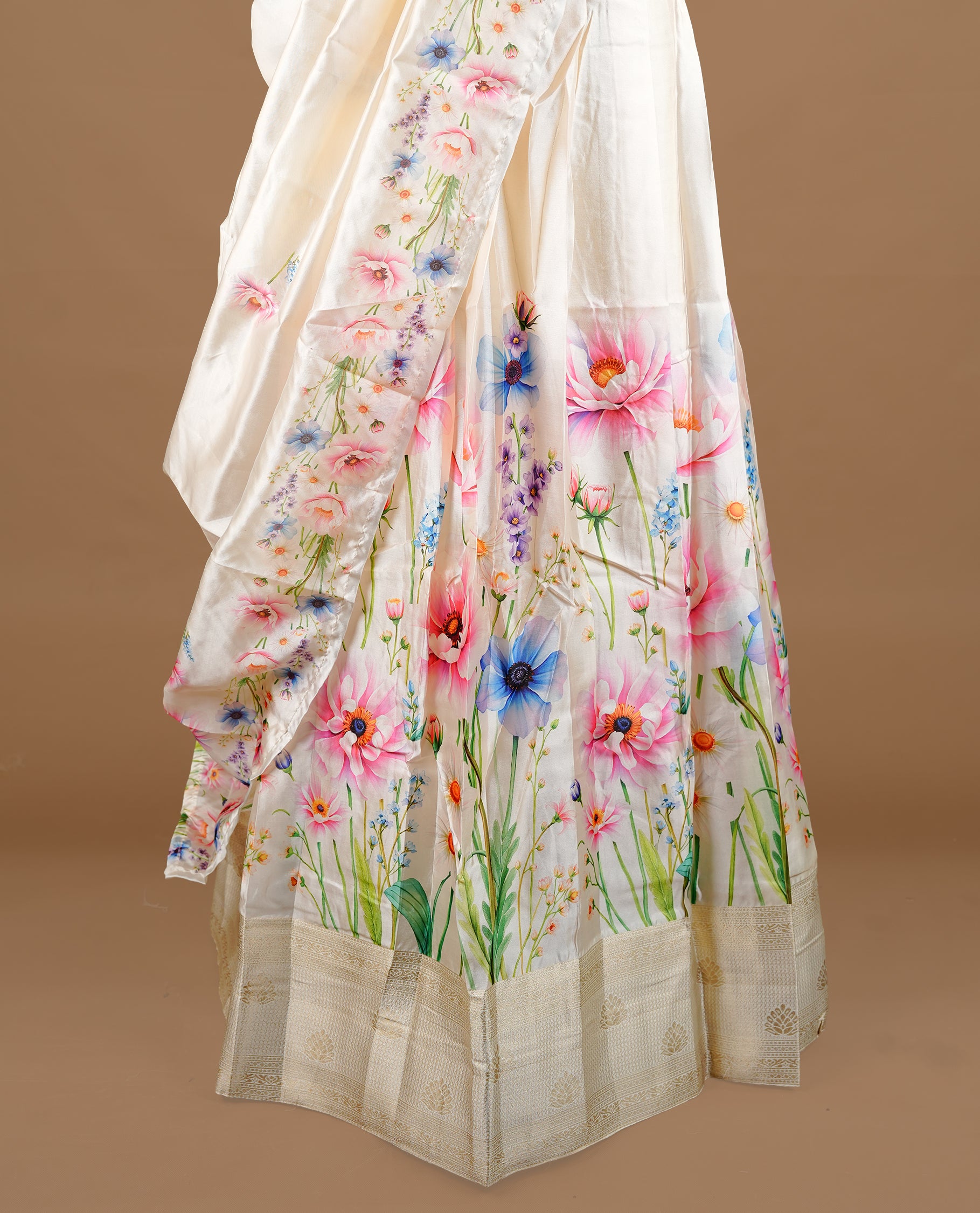 Off white colour semi stitched half saree featuring elegant pink colour floral prints, paired with a cream with traditonal zari border and matching printed dupatta ,paired with matching blouse piece.