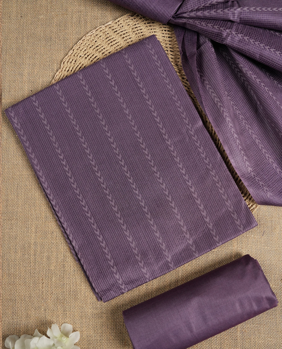 Lavender colour tussar suit material adorned with intricate woven patterns and subtle motifs, exuding ethnic elegance & Paired with a beautifully bordered dupatta and a matching plain bottom.