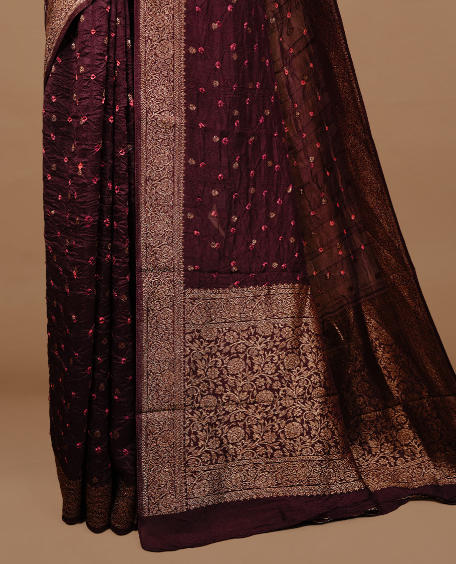 Chocolate brown colour Banarasi Bandhani silk saree featuring intricate antique zari circle Buttas across the body, complemented by an elegant antique zari border. Comes paired with a matching blouse piece