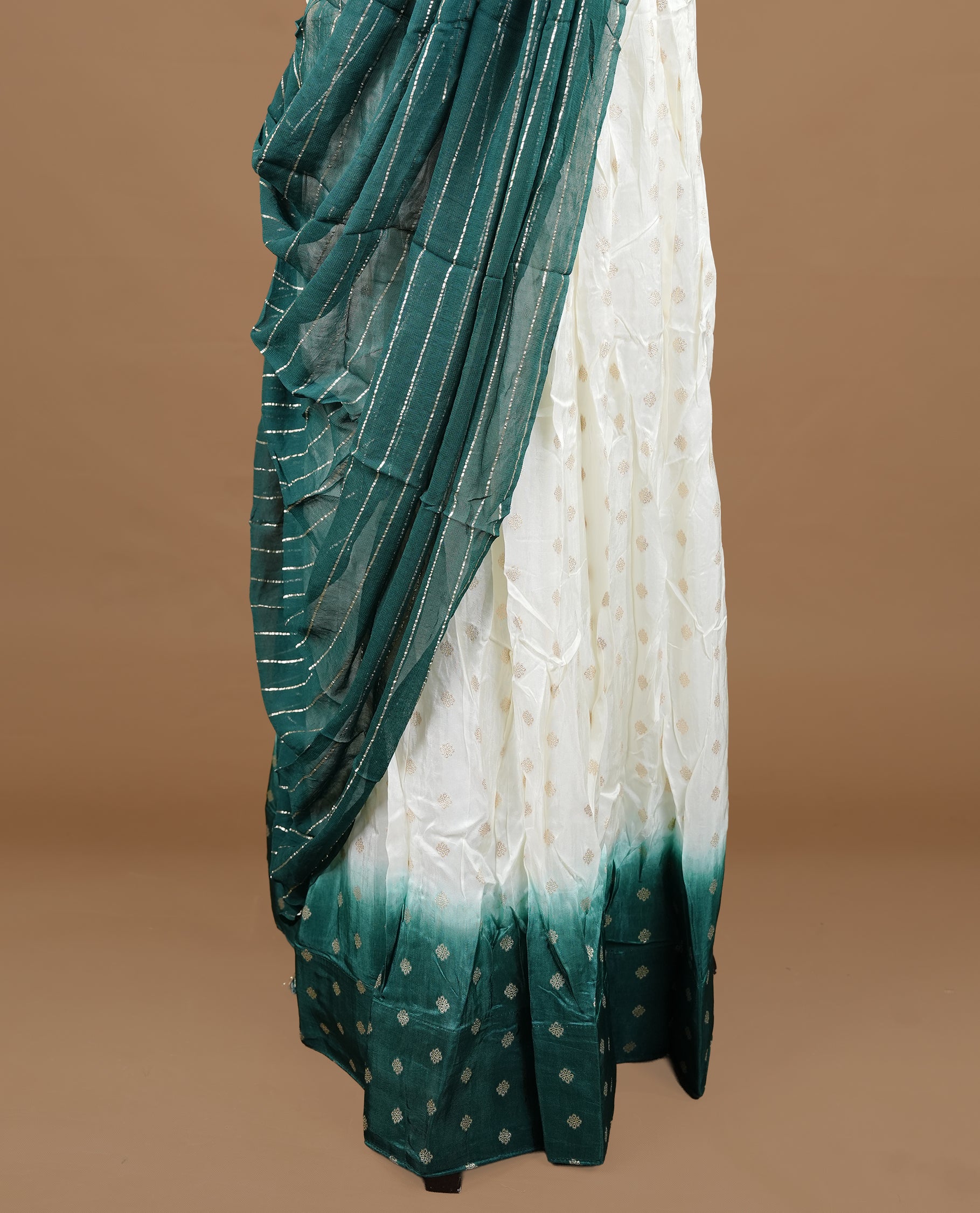 Off white colour semi stitched half saree featuring elegant zari buttas on the body, paired with a contrast green border and matching motifs dupatta,paired with matching blouse piece.