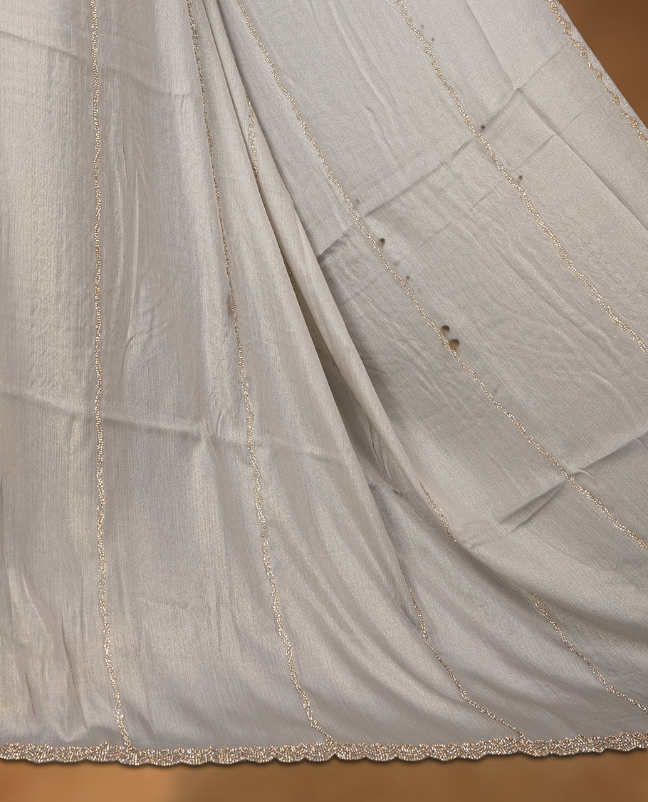 Gray silver Colour net shimmer fancy saree adorned with strip gold stone buttas all over the body, paired with a delicate stone worked border and matching blouse