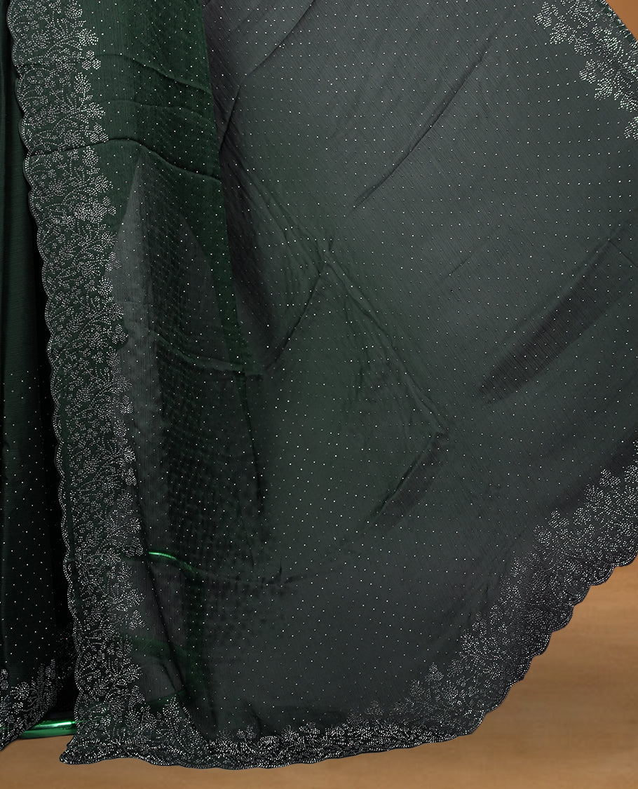 Deep bottle-green chiffon designer saree adorned with delicate white stone work across the body, enhanced with a heavy scalloped stone border and pallu. Paired with a matching stone-detailed blouse.