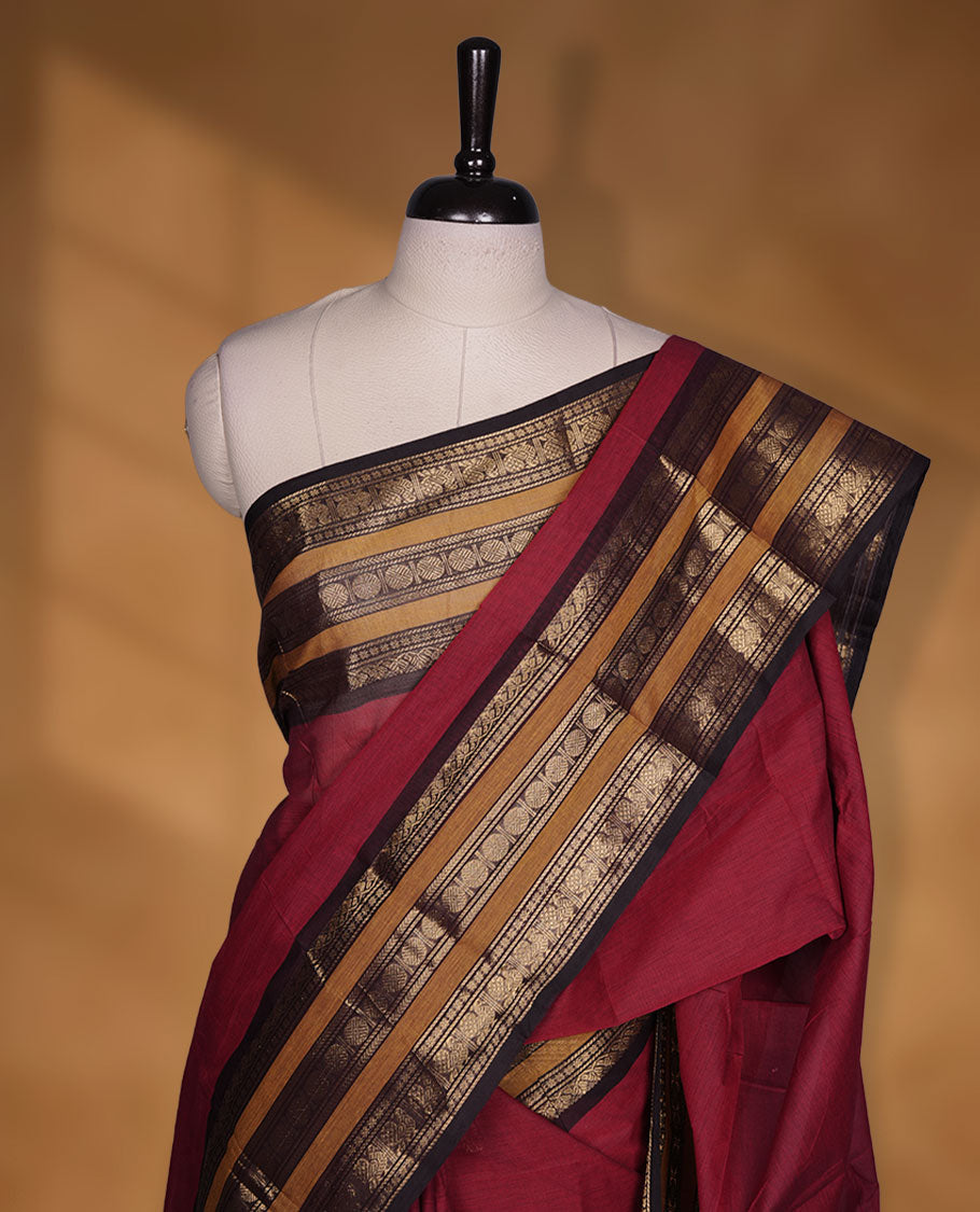 Maroon colour chettinad cotton saree featuring plain body, contrast chocolate brown and mustard colour with traditional gold zari border paired with matching blouse.
