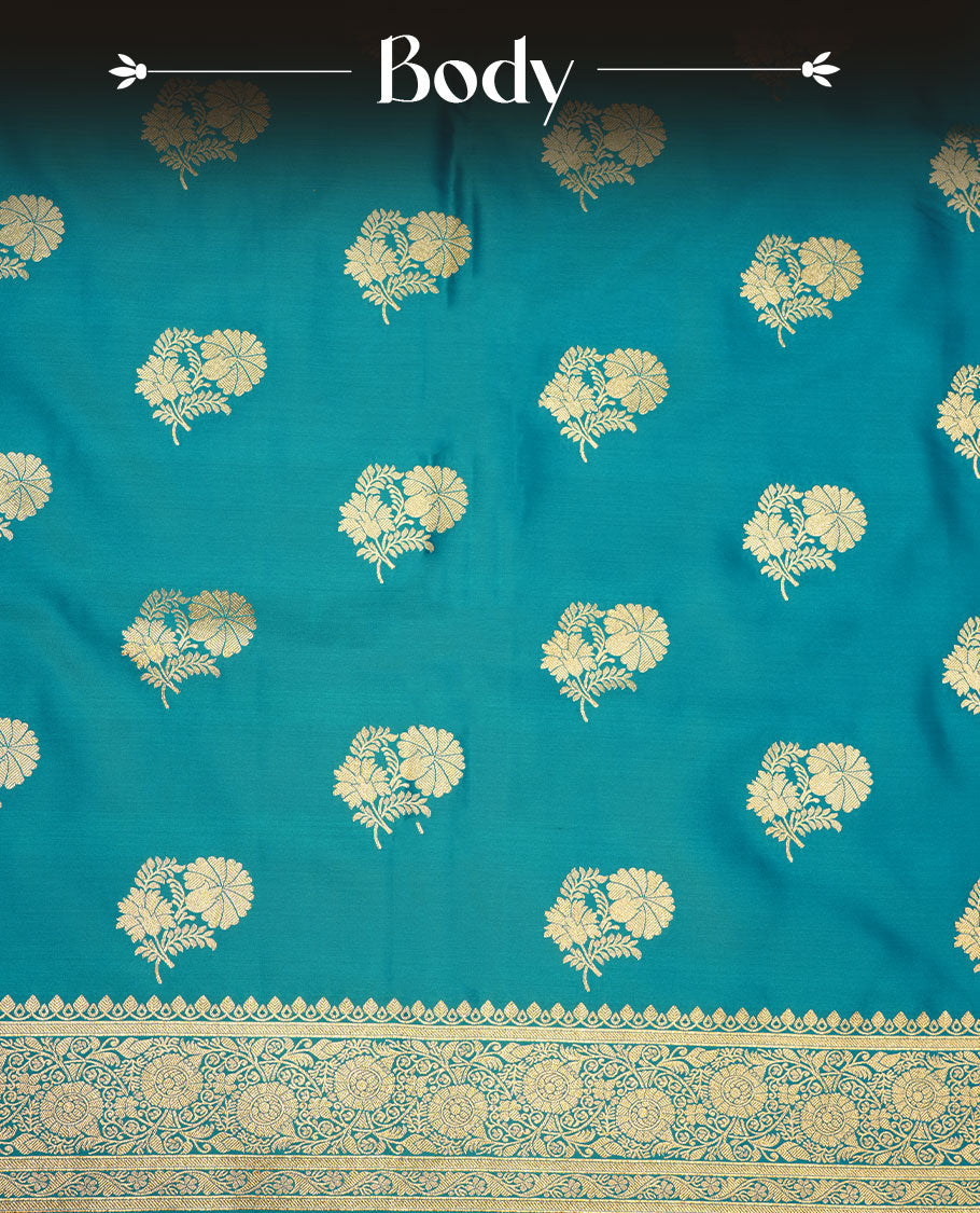Teal blue colour Banaras Satin Crepe saree featuring gold zari floral motifs on the body, a richly woven traditional border with intricate gold zari detailing, and paired with a matching blouse.